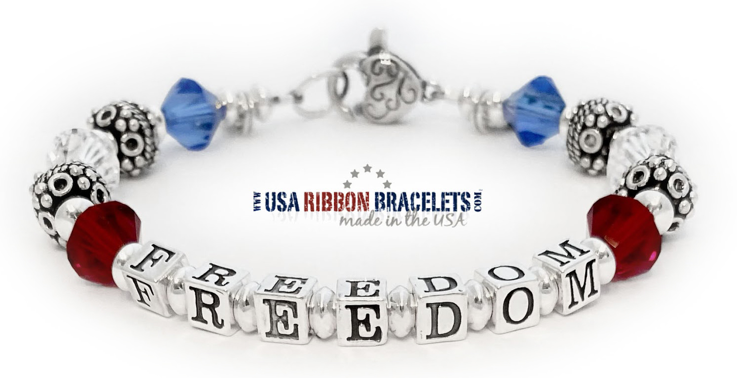 Red, white, and blue Swarovski crystal bracelet with cross charm spelling Freedom.